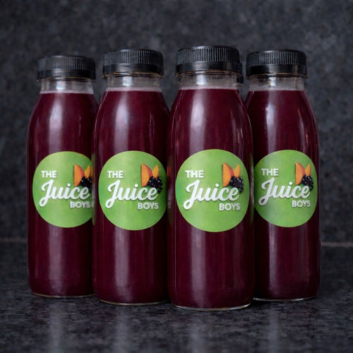 Four bottles of 'The Juice Boys' juice on a dark background